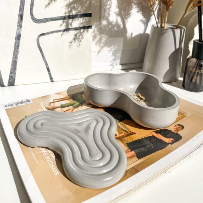 Boîte décorative Wavy en béton utilisée comme rangement design.