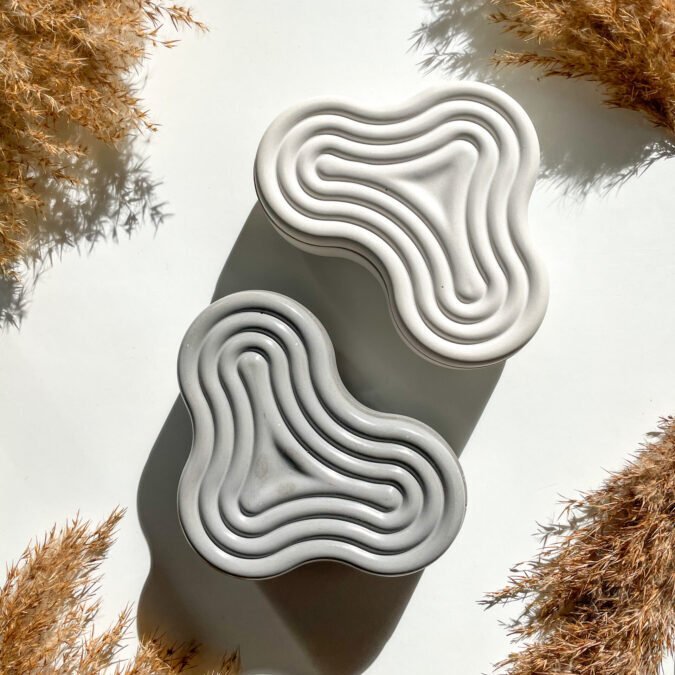 Boîte de rangement Wavy en béton disponible en coloris gris et blanc.