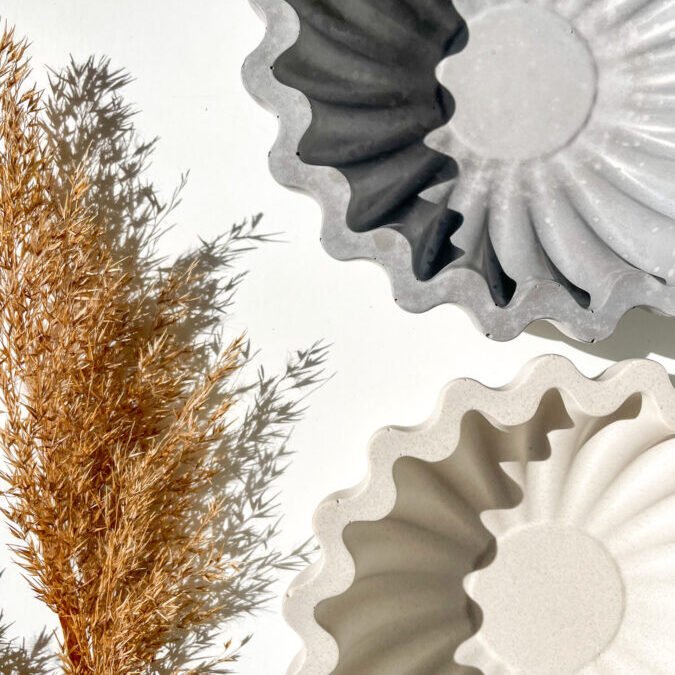 Bol décoratif Wavy en béton disponible en coloris gris et blanc.