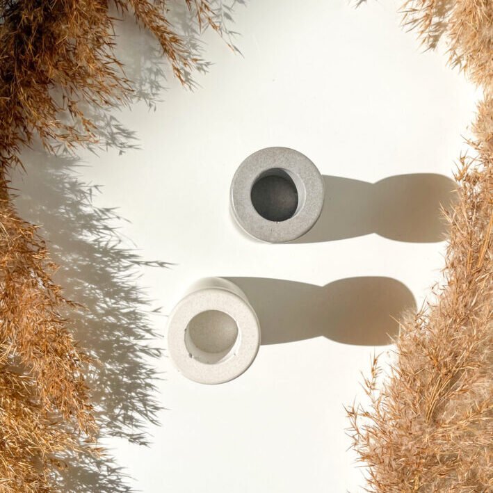Deux bougeoirs minimalistes en béton blanc et gris, fait à la main.