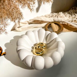 Coupelle organique en béton utilisée comme porte-bijoux.