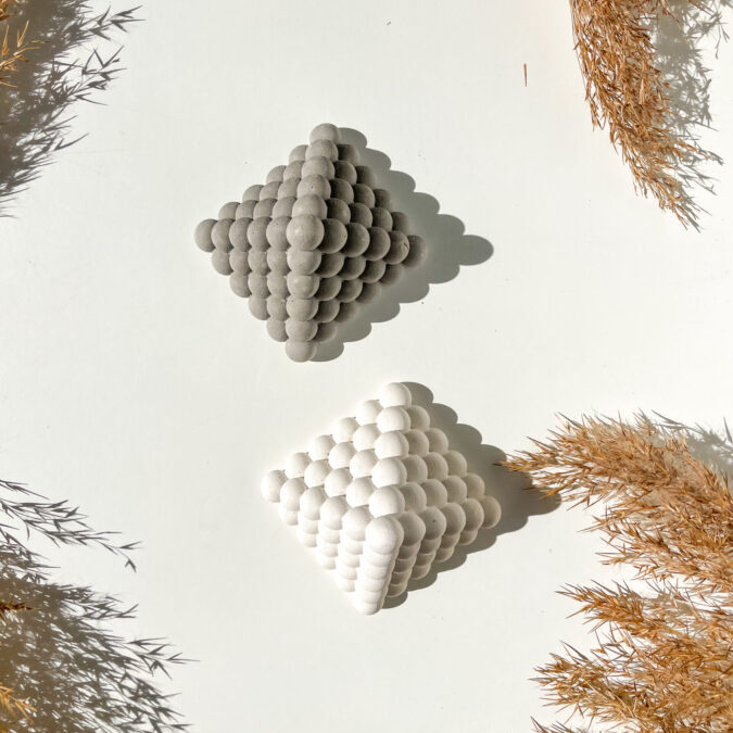 Objet décoratif pyramide Bubble en béton disponible en coloris gris et blanc, vue de dessus.