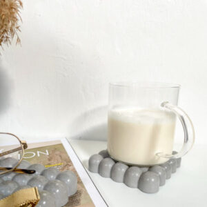 Lot de 2 dessous de verre carrés Bubble en béton sur une table au style minimaliste, fabriqué à la main.