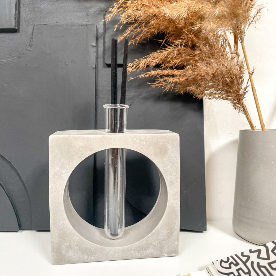 Diffuseur de parfum géométrique en béton gris dans une décoration minimaliste.