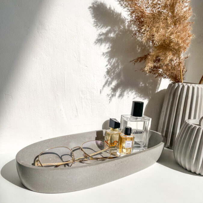 Grande coupelle en béton utilisée comme vide-poche décoratif pour accessoires.