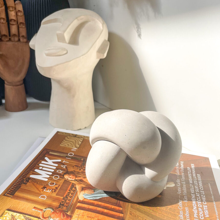 Objet décoratif en forme de nœud en béton dans un intérieur contemporain.