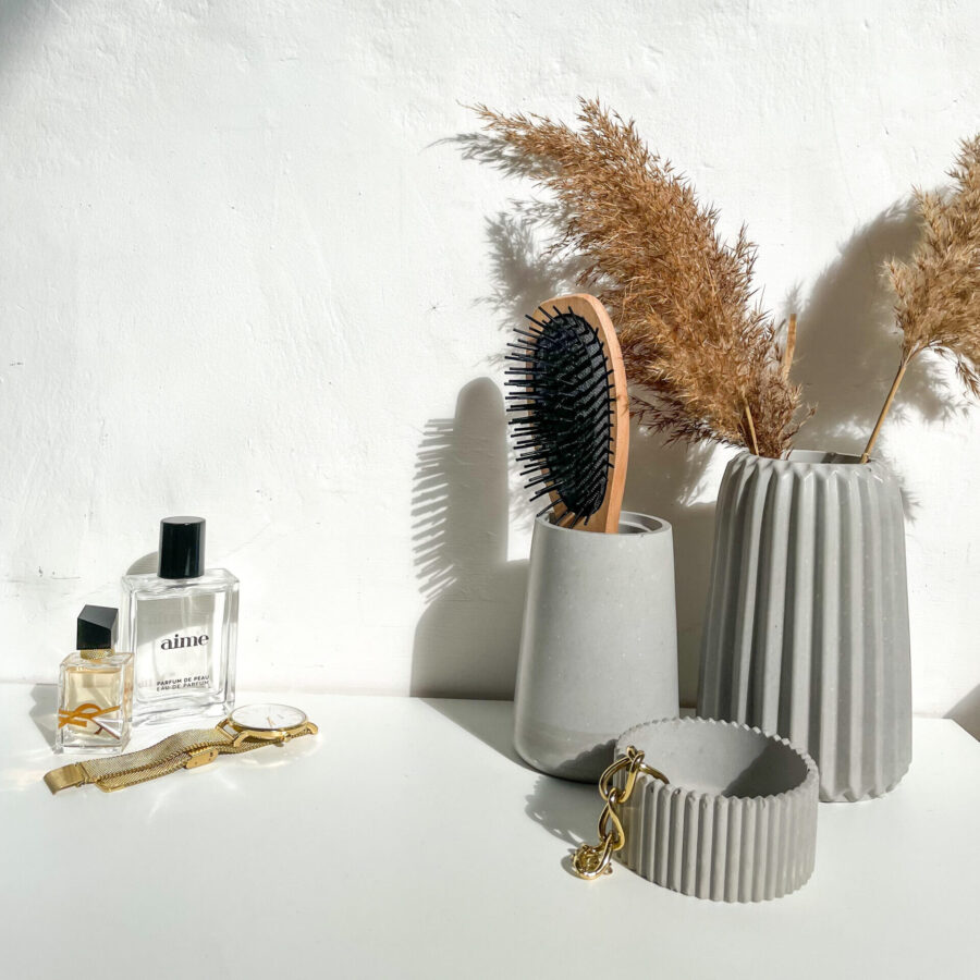 Petit pot décoratif strié en béton dans une décoration d'intérieur minimaliste, fait à la main.