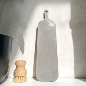Planche longue décorative en béton utilisée comme objet de décoration dans un intérieur minimaliste.