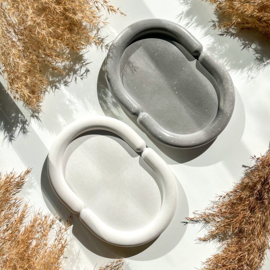 Plateau ovale organique en béton disponible en coloris gris et blanc.