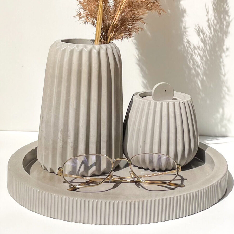 Plateau rond à relief strié en béton dans une décoration intérieure minimaliste, pour entrée ou salle de bain.