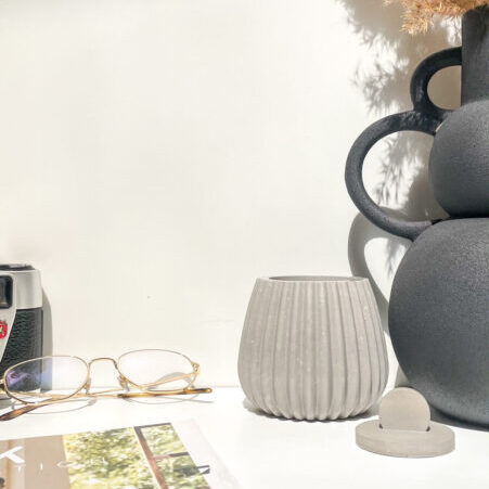 Pot de rangement avec couvercle en béton au design strié.