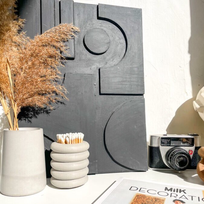 Pot cylindrique empilé en béton dans une décoration contemporaine.