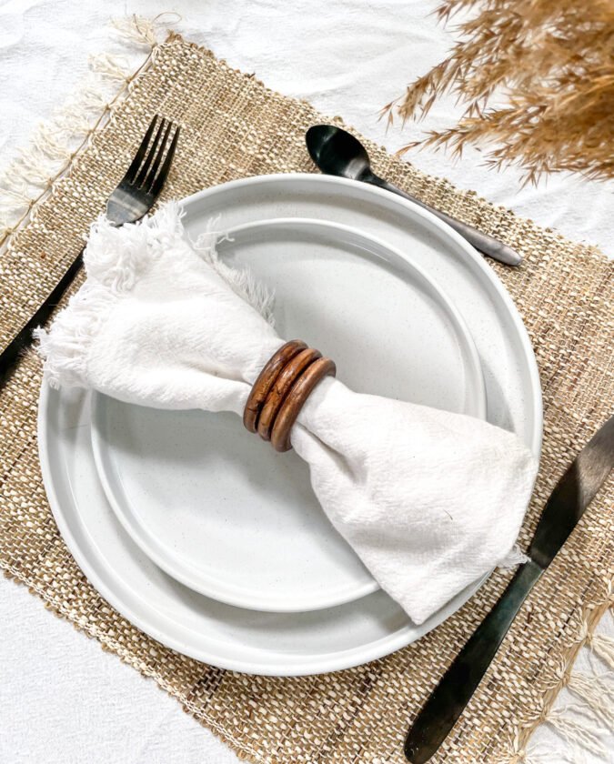 Lot de 4 ronds de serviette en bois dans une décoration de table élégante pour un repas de mariage ou de baptême.