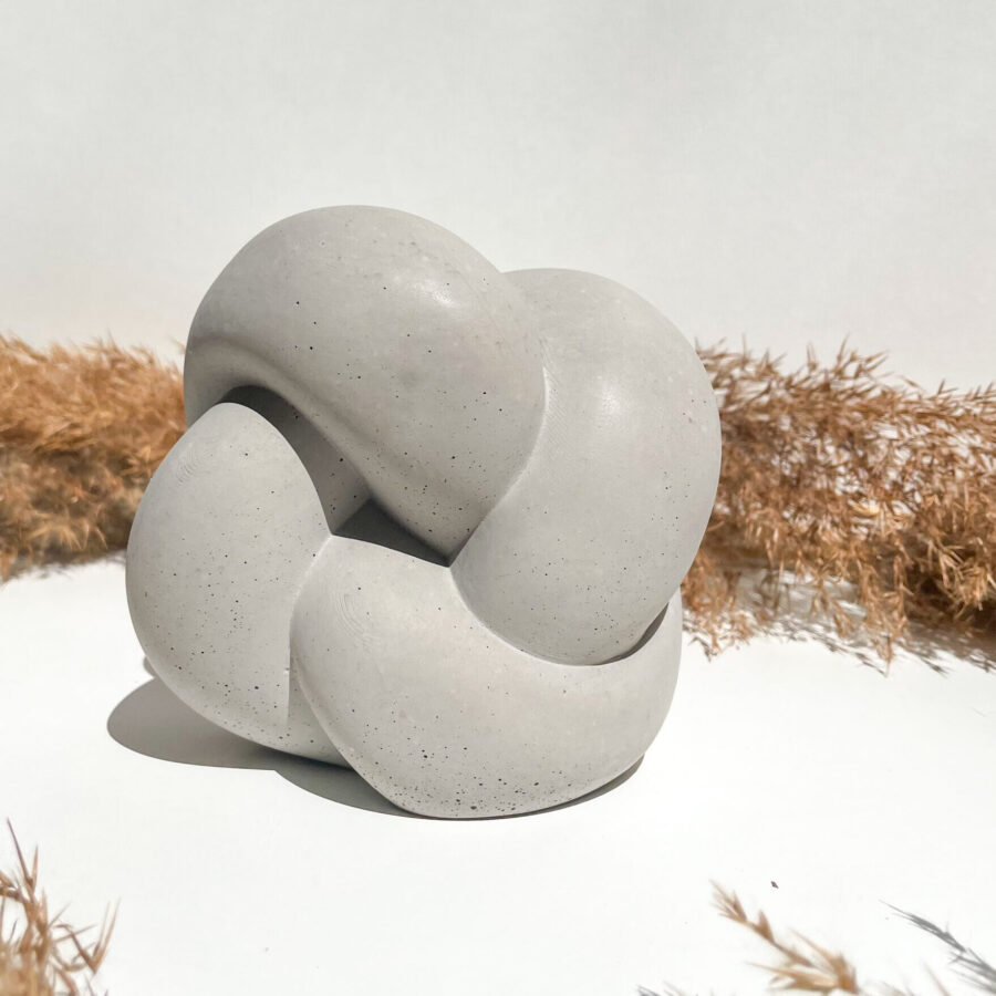 Sculpture décorative en forme de nœud en béton gris fabriquée à la main.
