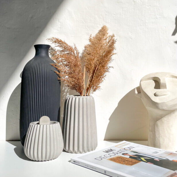Vase strié en béton dans une décoration intérieure minimaliste, fait à la main.
