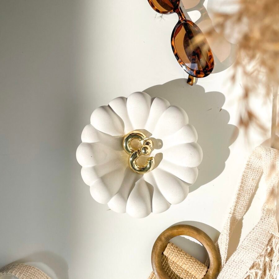 Vide-poche organique en béton blanc dans une décoration minimaliste.