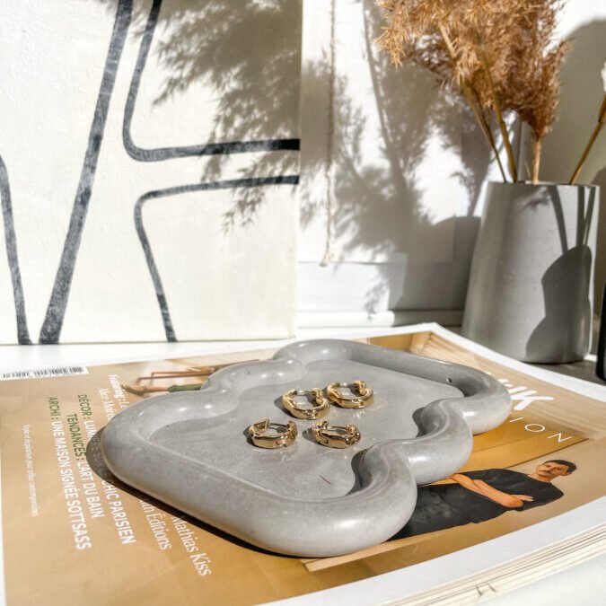 Plateau Wavy en béton utilisé comme vide-poche dans une décoration contemporaine.