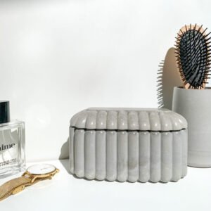 Boîte organique en béton utilisée comme rangement pour bijoux.