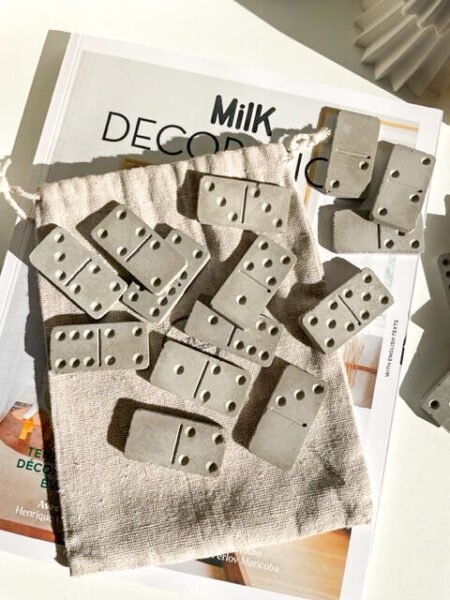 Jeu de dominos en béton avec pochette de rangement en tissu.